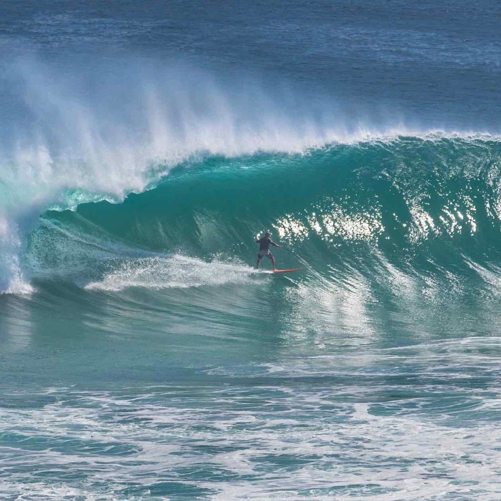 Man surfing huge wave at Uluwatu surf break