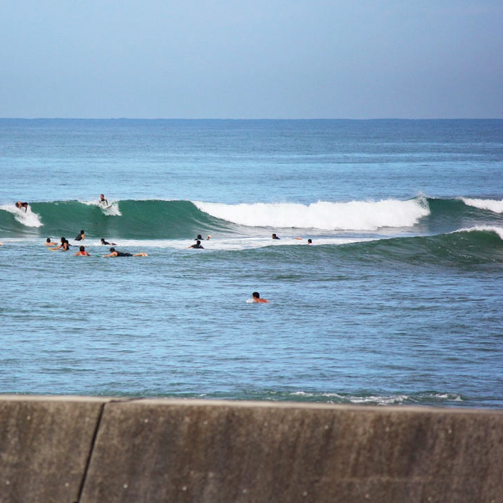 Surfers catching waves at a surf spot in Wakayama, Japan