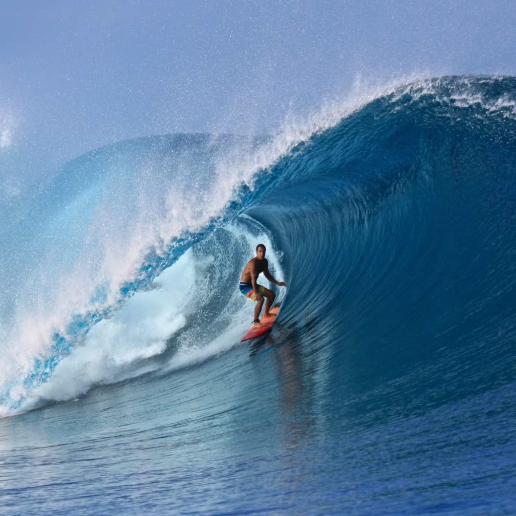 A man surfs a huge barrel at Cloudbreak surf spot in Tavarua, Fiji