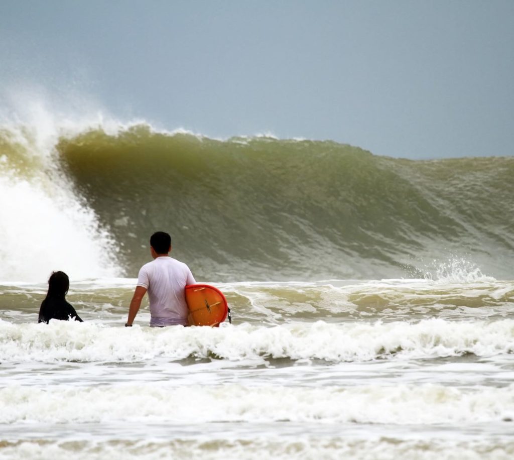 surfers looking at huge wave in cherating malaysia