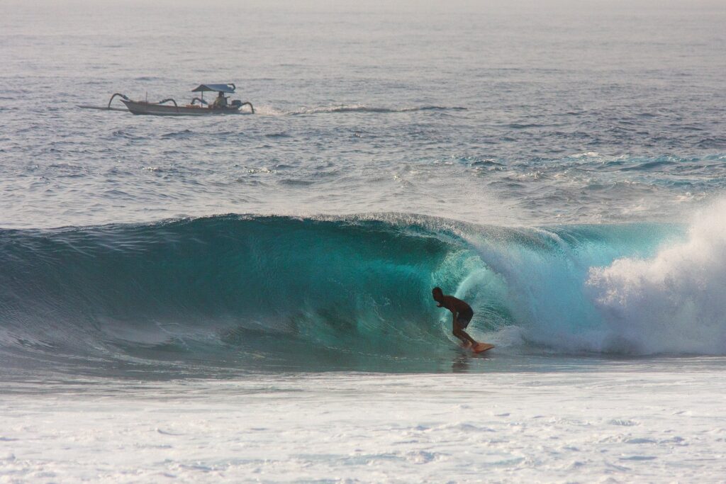 Surfer riding wave at Nusa Dua in Bali, Indonesia