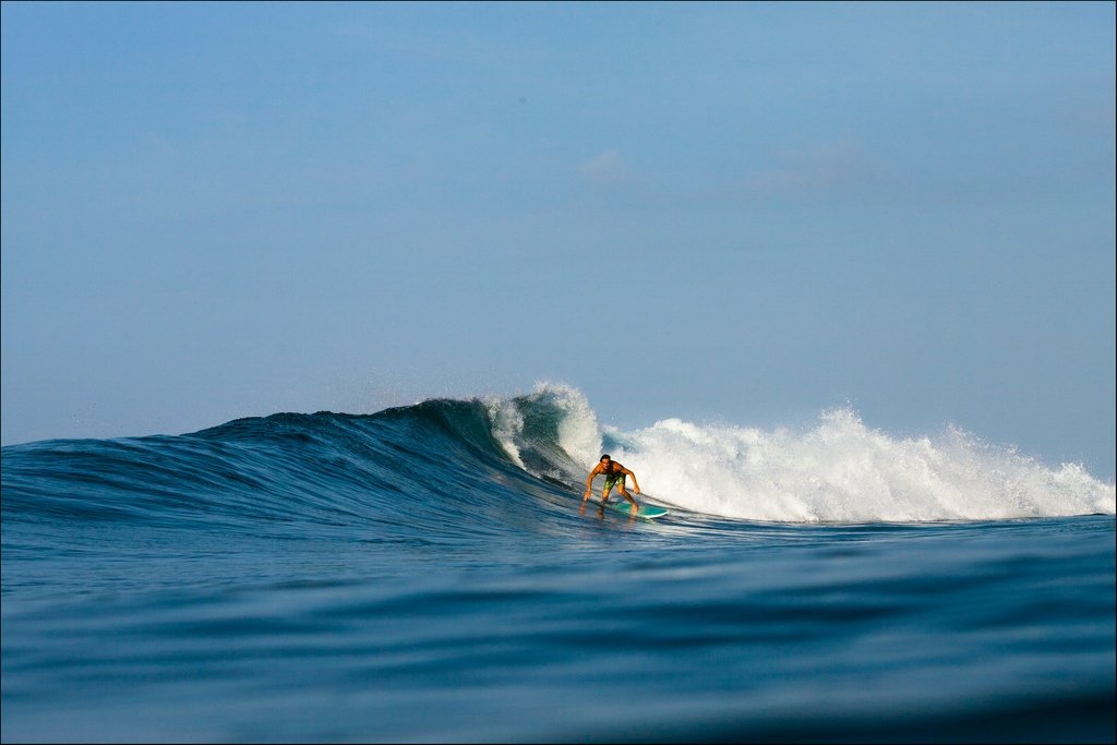Surfer riding wave at Green Ball - best surf spots in Bali, Indonesia